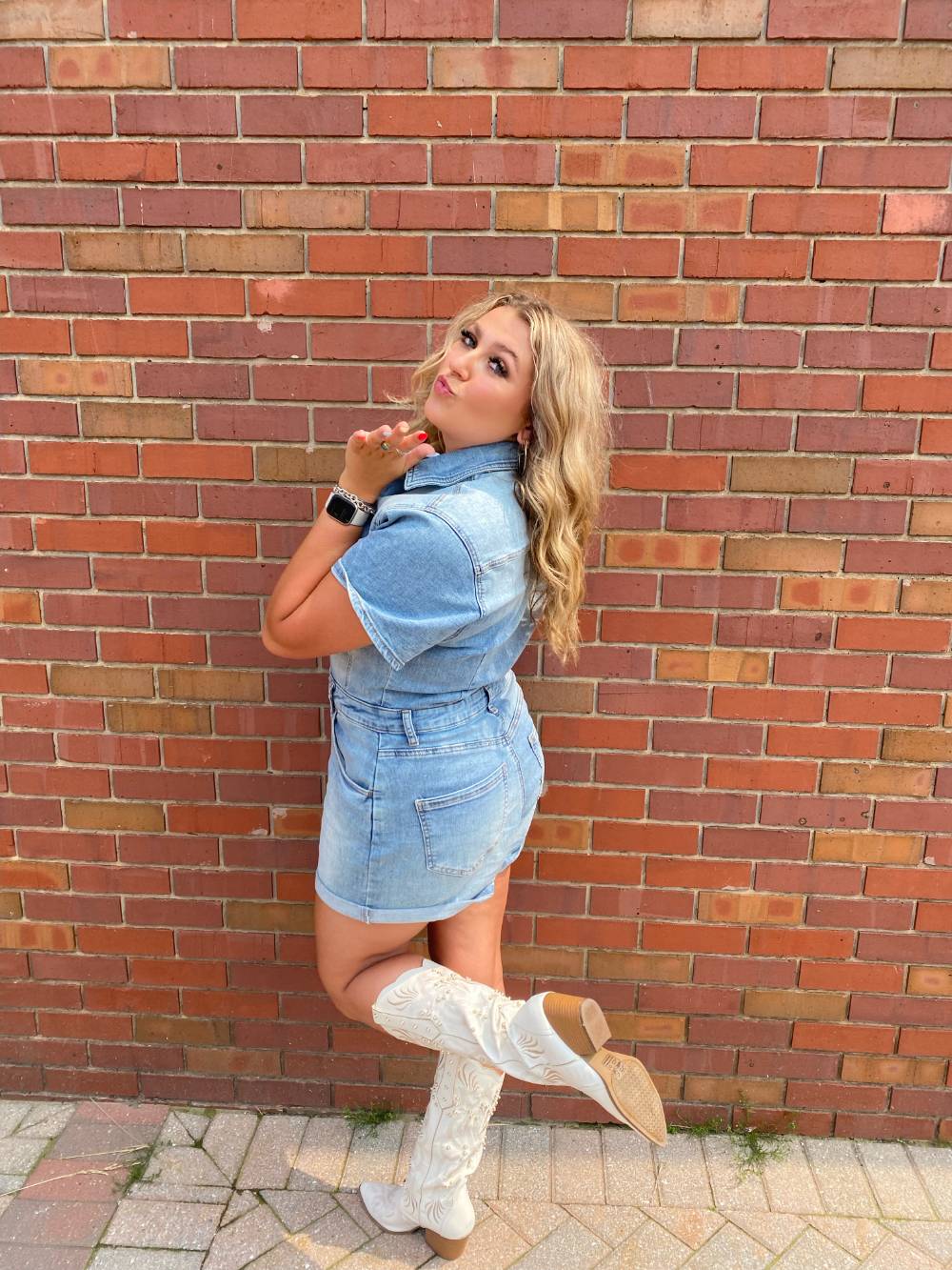 Image 1 of 2 Female student standing in front of brick wall